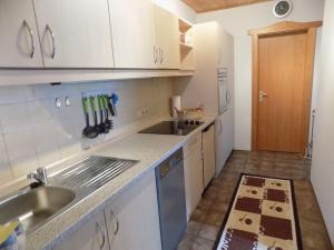 a small kitchen with white cabinets and a sink at Ferienwohnung Waldblick FEWO 502 in Freudensee