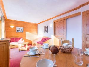 a dining room with a table and a living room at Appartement Plagne Villages, 3 pièces, 6 personnes - FR-1-181-2625 in La Plagne Tarentaise