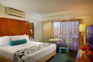 Llit o llits en una habitació de Oasis Hotel Waikiki