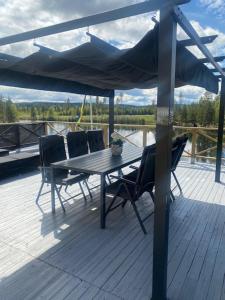 una terraza de madera con mesa y sillas en un barco en Tallbacken Fritidsby, en Brännan
