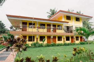 邦勞的住宿－Villa Lourdes Resort，带阳台的大型黄色房屋