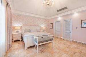 a bedroom with a white bed and a chandelier at Magical apartment in Fundadores in Punta Cana