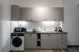 a kitchen with a washing machine and a sink at Central Elegant Flat in Patra