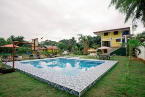 a swimming pool in front of a house at Villa Lourdes Resort in Panglao