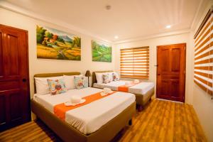 a hotel room with two beds and a window at Villa Lourdes Resort in Panglao