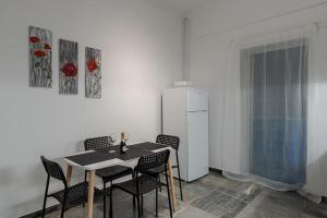 a dining room with a table and chairs and a refrigerator at Central Elegant Flat in Patra