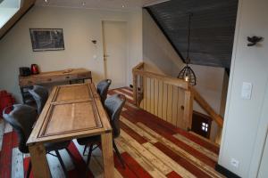 a dining room with a wooden table and chairs at N-Joy in Westvleteren