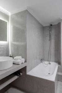 La salle de bains est pourvue d'une baignoire, d'un lavabo et d'une douche. dans l'établissement Central Elegant Flat, à Patras
