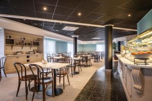 a restaurant with tables and chairs and a bar at Thon Hotel Brussels Airport in Diegem