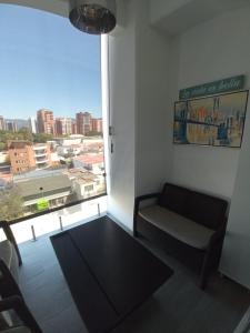- un salon avec un canapé et une grande fenêtre dans l'établissement APARTAMENTO CON TERRAZA CERCA DEL AEROPUERTO, à Guatemala