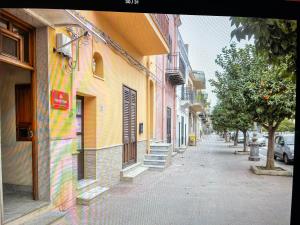 une rue de la ville avec des bâtiments, des arbres et un trottoir dans l'établissement CASA DEL CORSO, à Cinisi