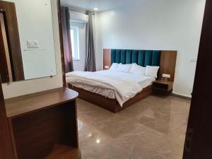 um quarto com uma cama com uma cabeceira azul em AKS INTERNATIONAL HOTEL AND RESORT em Sasarām