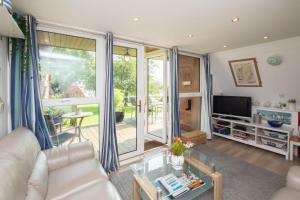 een woonkamer met een bank en een groot raam bij Chalet One in Deal