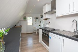 een keuken met witte kasten en een aanrechtblad bij Chalet One in Deal