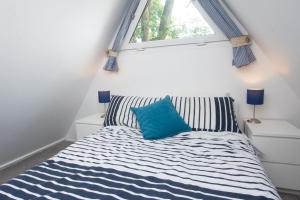 een slaapkamer met een bed met een blauw kussen erop bij Chalet One in Deal