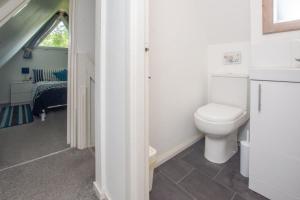een witte badkamer met een toilet en een raam bij Chalet One in Deal +17 foto's