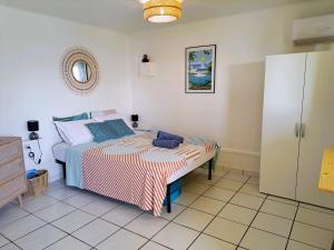 ein Schlafzimmer mit einem Bett und einer Kommode in der Unterkunft Bungalow Java - Bassin Manapany-Les-Bains in Saint-Joseph