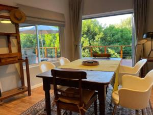a dining room with a table and chairs and a balcony at Wild Plum in Knysna