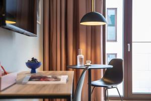 une chambre avec une table, une chaise et une lampe dans l'établissement ipartment Leverkusen, à Leverkusen