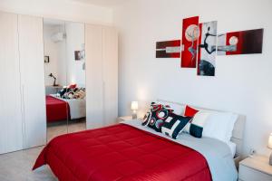 una camera con un letto rosso e una coperta rossa di A casa di Vito a Mazara del Vallo