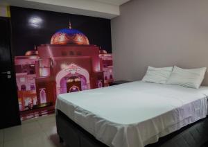 a bedroom with a bed with a building painted on the wall at Amazônia Palacce Hotel in Marabá