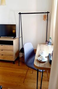 a room with a table and a chair and a television at Boutique Hotel Templ in Mikulov