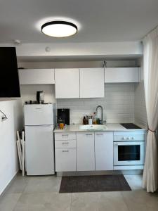 a white kitchen with a sink and a refrigerator at Sansa suite SeaSide Sea View dream Apartment in Eilat