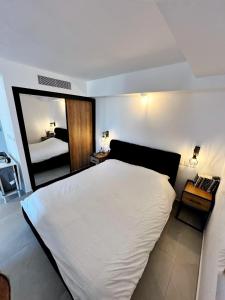 - une chambre avec un grand lit blanc et un miroir dans l'établissement Sansa suite SeaSide Sea View dream Apartment, à Eilat