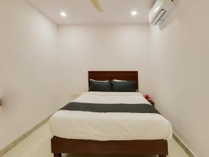 a bedroom with a bed in a white room at Collection O HOTEL BEDS INN in Maula Ali