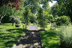 un camino en un parque con árboles y césped en Ferienhaus Wieke - eine Oase der Erholung, en Wiesmoor