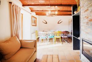 uma sala de estar com um sofá, uma mesa e cadeiras em Masia d'en cot em Puigcerdà