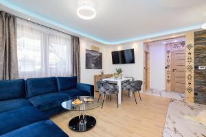 a living room with a blue couch and a table at Unique Apartment for 6 People in Zakopane with Access to Sauna by Renters in Zakopane