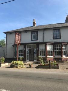 a building on the side of a street with a sign at The Penruddocke Arms in Dinton