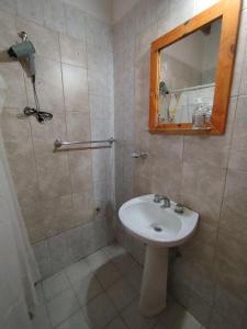 Un baño con lavabo y ducha con espejo. en Departamento El Virula, en Villa Unión