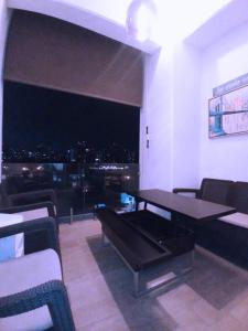 een eetkamer met een tafel en uitzicht op de stad bij APARTAMENTO CON TERRAZA CERCA DEL AEROPUERTO in Guatemala