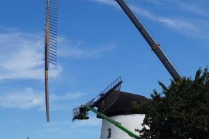 une grue monte un bâtiment avec un escalier dans l'établissement Mühlenurlaub Südheide, à Wittingen