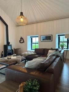 - un salon avec un canapé en cuir brun dans l'établissement Croft Cottage by Mourne Homestays, à Glasdrumman
