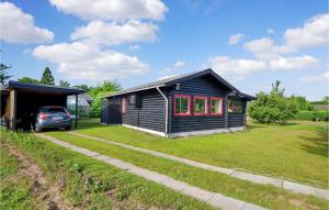 una casa nera con una macchina parcheggiata di fronte di Two-Bedroom Holiday Home In Nordborg a Nordborg