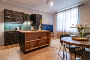 a kitchen and dining room with a table and a counter at STING Boutique Apartments in Ostrava