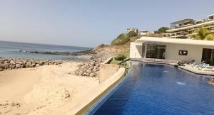 a house with a swimming pool next to a beach at Bel Appartement en face de la mer in Dakar