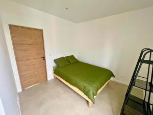 1 dormitorio con 1 cama con manta verde en Pleyel cosy, en Saint-Denis