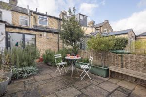 a patio with a table and chairs in a backyard at Beautiful Victorian house in central Cambridge in Cambridge