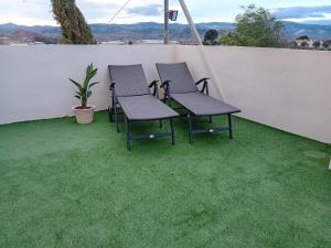 a group of chairs on a patio with grass at Casa nuestro sueño in Partaloa