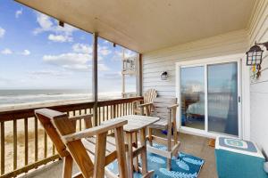a porch with a table and chairs and the ocean at Seven B Heaven in Rodanthe