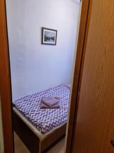 a small bed with purple sheets in a room at Studio apartman Šapudl in Vukovar