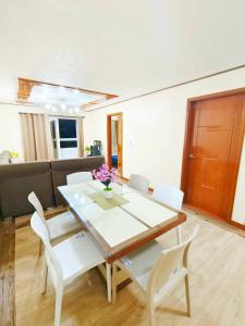 a living room with a table and white chairs at 2BR Condo near Burnham in Baguio