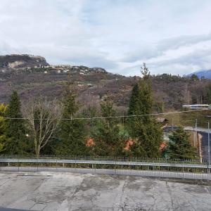 a parking lot with a fence and mountains in the background at Casa Dany in Tremosine Sul Garda
