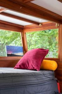 a bed with two pillows and a window at Slash Arts houseboat on secluded mooring in central London in London