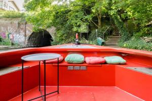 Un bote rojo con almohadas en el costado. en Slash Arts houseboat on secluded mooring in central London, en Londres