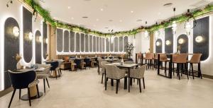 un comedor con mesas, sillas y plantas en Ilunion Les Corts Spa en Barcelona